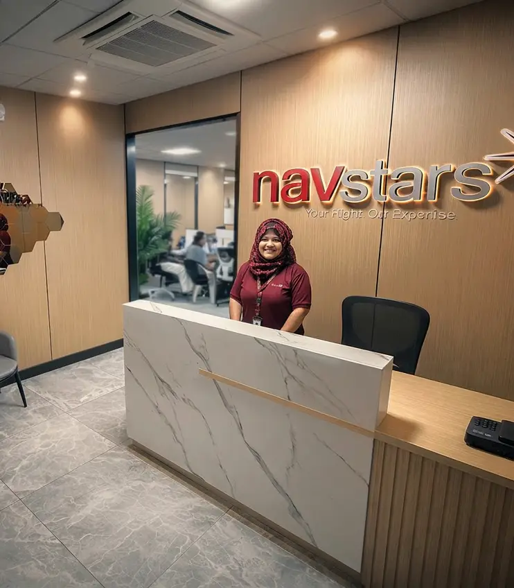 A NavStars team member smiling at the reception desk of the NavStars Philippines office, with the company logo and tagline visible on the wall behind her.